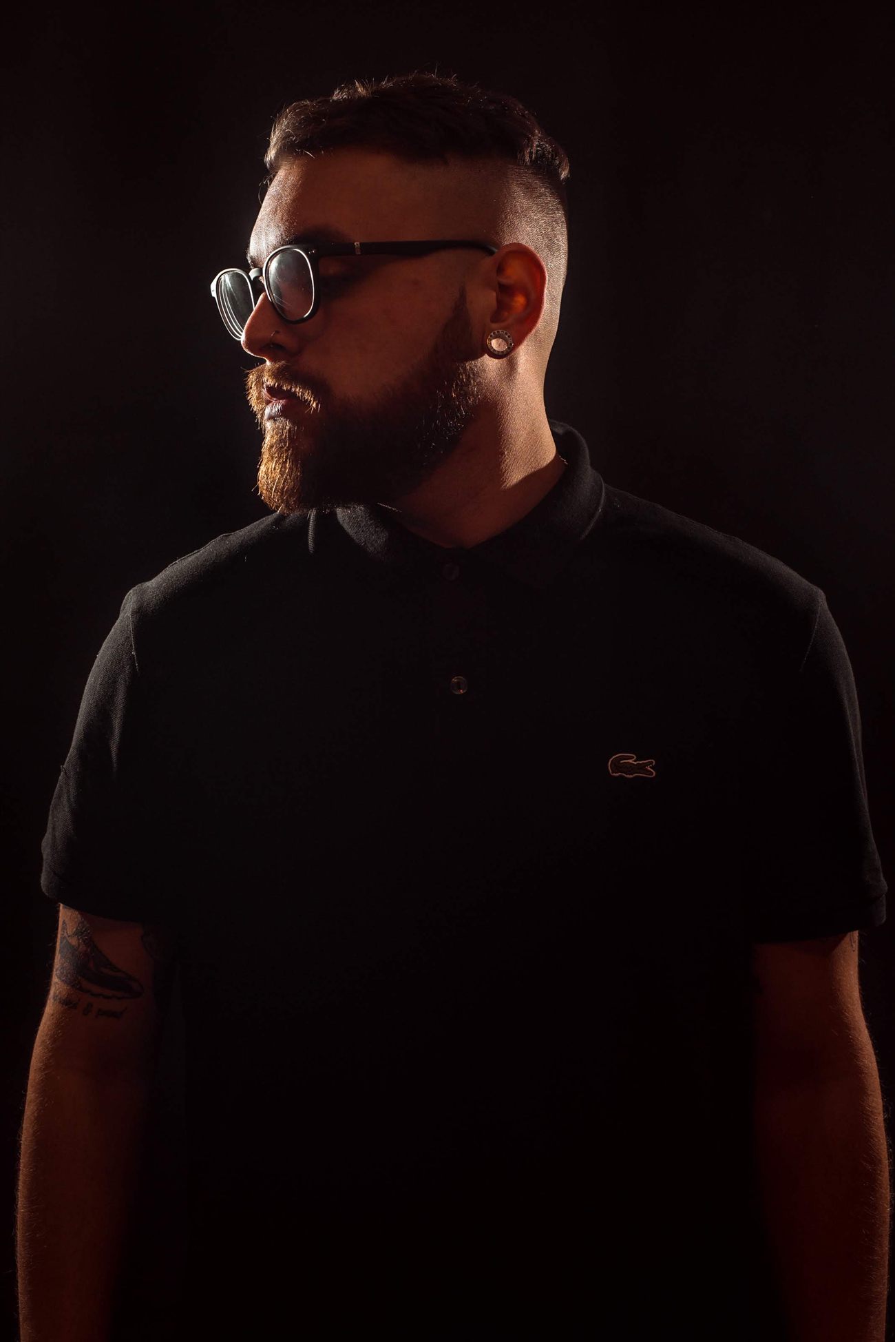 Retrato de Agustín Rose con lentes sobre fondo oscuro